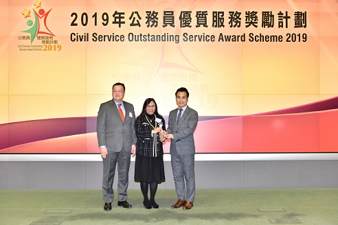 Ms Marianna Yu, Registry Manager (centre), accompanied by Mr Roger Wong, Deputy Registry Manager (left), received the Departmental Service Enhancement Award (Small Department Category) at the Prize Presentation Ceremony.