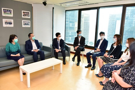 財經事務及庫務局局長許正宇(左二)與部門同事交談以了解他們的工作狀況及提供的服務詳情